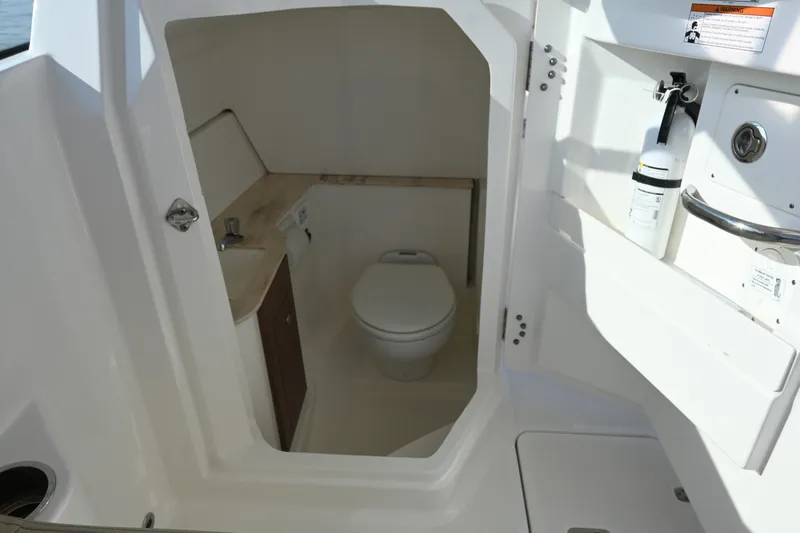 Slide: The Image of 2021 Pursuit DC 266 Dual Console boat interior with compact bathroom and safety equipment. - 23