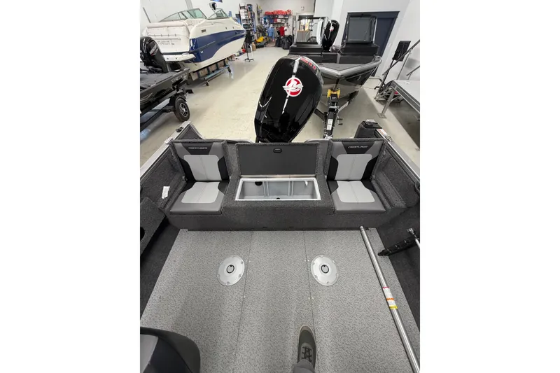 Slide: The Image of 2026 Crestliner 1750 Hawk WT boat interior with seating and motor in a showroom. - 19