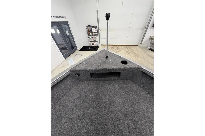 Slide: The Image of Interior view of 2026 Crestliner 1750 Hawk WT boat, showcasing carpeted deck and storage area. - 17