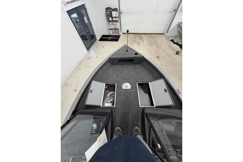 Slide: The Image of 2026 Crestliner 1750 Hawk WT boat interior with open storage compartments in showroom. - 16