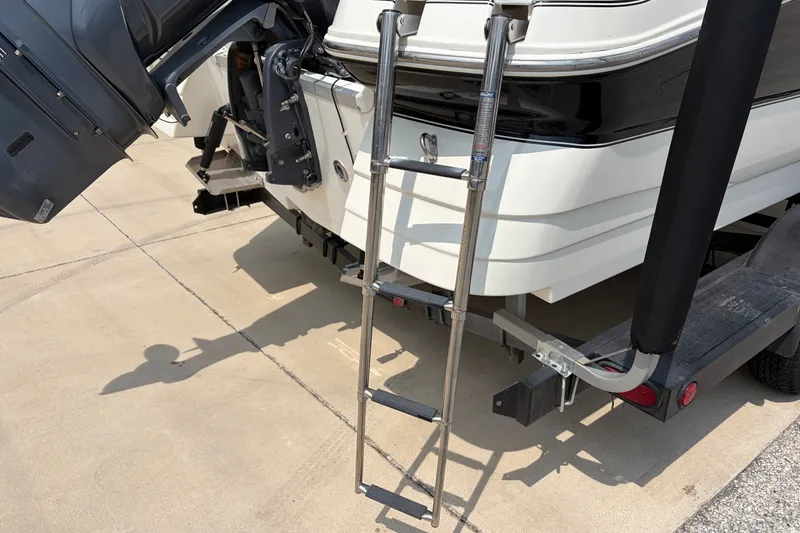 Slide: The Image of 2012 Hurricane SunDeck Sport 220 OB boat with ladder and outboard motor on trailer. - 21