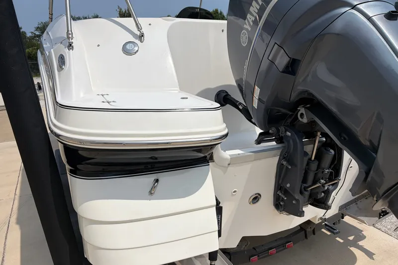 Slide: The Image of 2012 Hurricane SunDeck Sport 220 OB boat with Yamaha outboard motor, docked on a sunny day. - 14