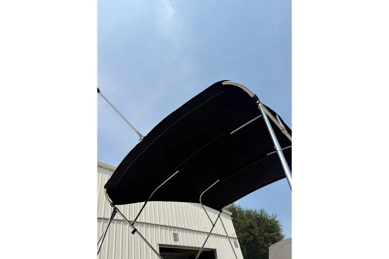 Slide: The Image of 2012 Hurricane SunDeck Sport 220 OB boat canopy against a clear sky. - 20