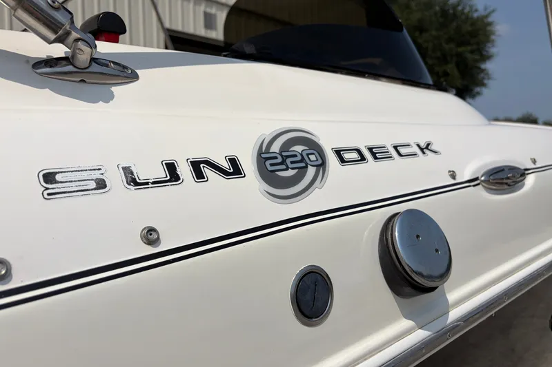 Slide: The Image of 2012 Hurricane SunDeck Sport 220 OB boat logo and details on white hull. - 19