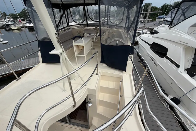 Slide: The Image of 2004 Mainship 390 Trawler's upper deck with helm station and marina view. - 10