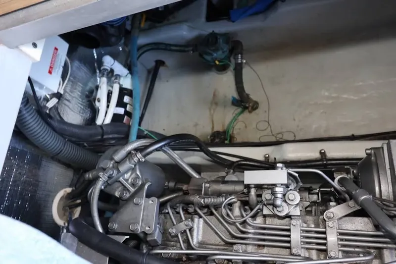 Slide: The Image of Engine compartment of a 2004 Mainship 390 Trawler, showcasing mechanical components and wiring. - 25
