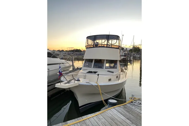 The Image of 2004 Mainship 390 Trawler docked at sunset, showcasing its elegant design and marina setting. - 0