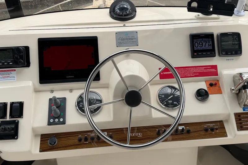 Slide: The Image of 2004 Mainship 390 Trawler helm with steering wheel, gauges, and navigation equipment. - 3