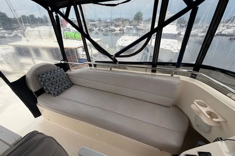 Slide: The Image of 2004 Mainship 390 Trawler interior with cushioned seating and marina view. - 5