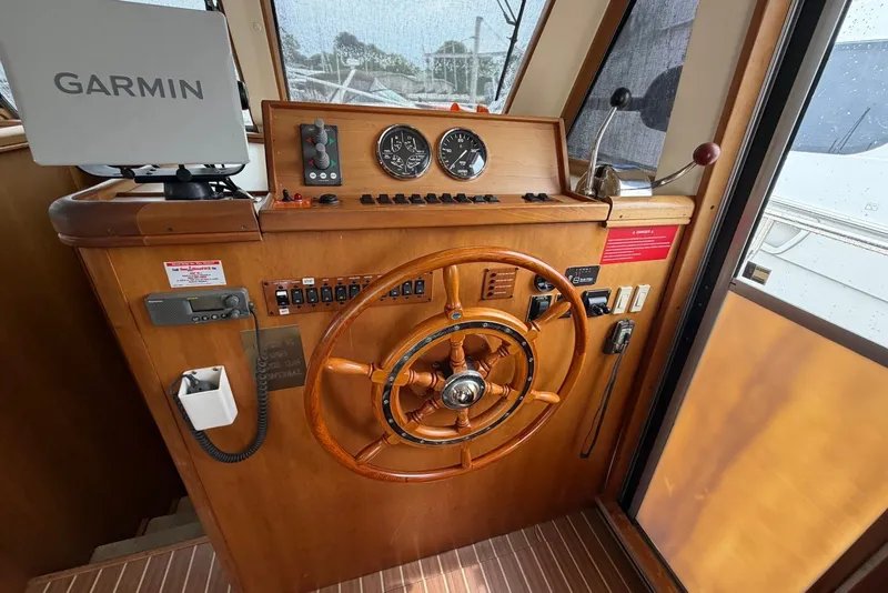 Slide: The Image of 2004 Mainship 390 Trawler helm with Garmin navigation and wooden steering wheel. - 13