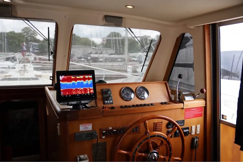 Slide: The Image of 2004 Mainship 390 Trawler helm with navigation equipment and wooden steering wheel. - 12