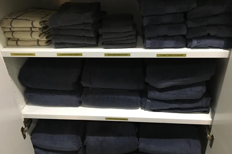 Slide: The Image of Neatly organized towels in a cabinet, labeled by type and color, aboard Adonia Azul Trip. - 32