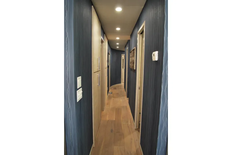 Slide: The Image of Narrow hallway with blue walls, wooden floor, and recessed lighting on Adonia Azul Trip. - 12