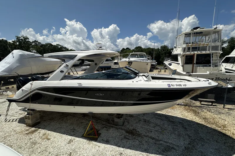 Slide: The Image of 2018 Sea Ray SLX 310 Outboard boat displayed in a marina under a sunny sky. - 43