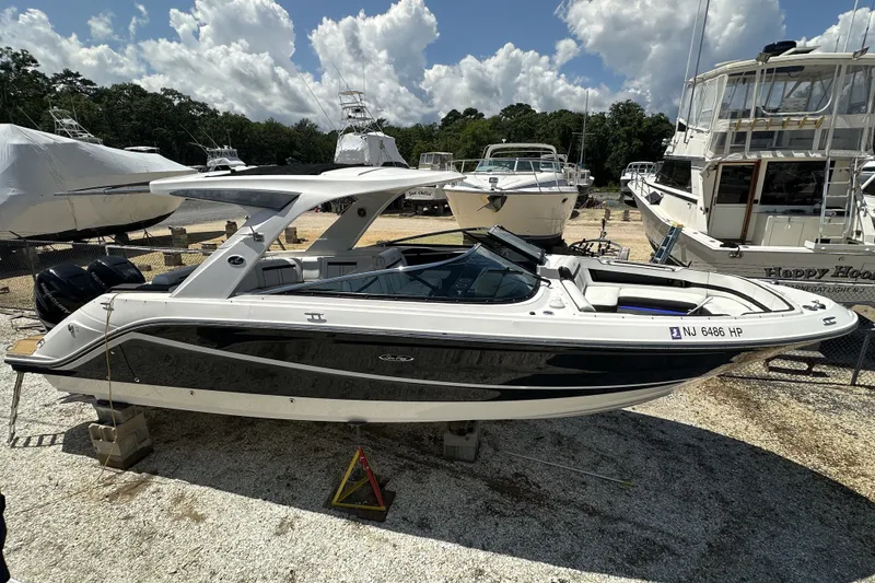 The Image of 2018 Sea Ray SLX 310 Outboard boat on display, surrounded by other vessels under a sunny sky. - 0