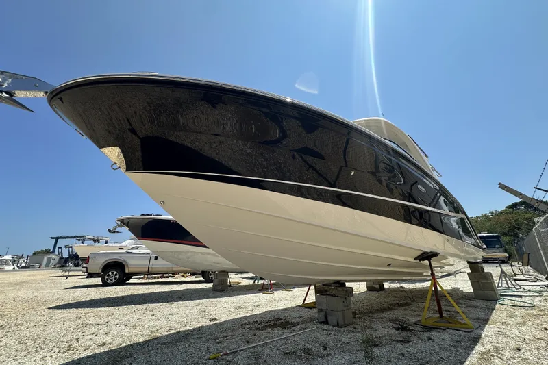Slide: The Image of 2018 Sea Ray SLX 310 Outboard boat on dry dock under clear blue sky. - 44