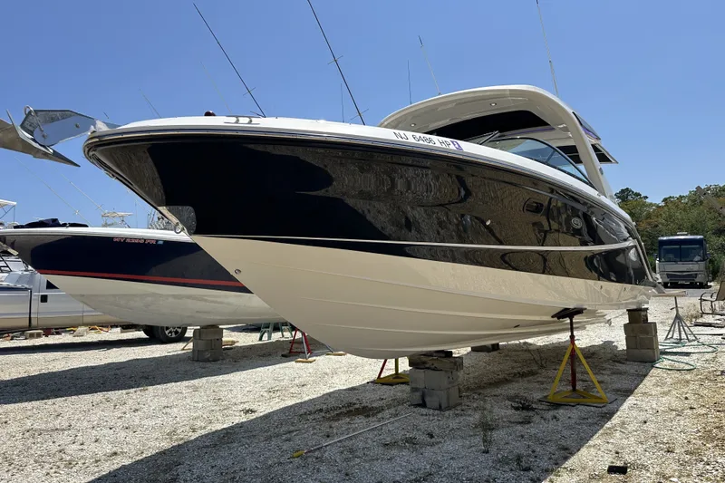 Slide: The Image of 2018 Sea Ray SLX 310 Outboard boat on stands, displayed outdoors. - 38