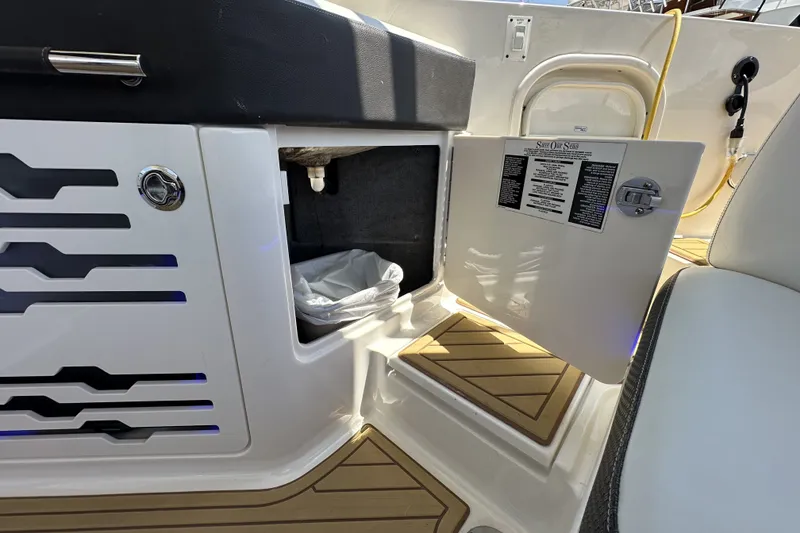 Slide: The Image of 2018 Sea Ray SLX 310 Outboard boat interior with open storage compartment and teak flooring. - 32