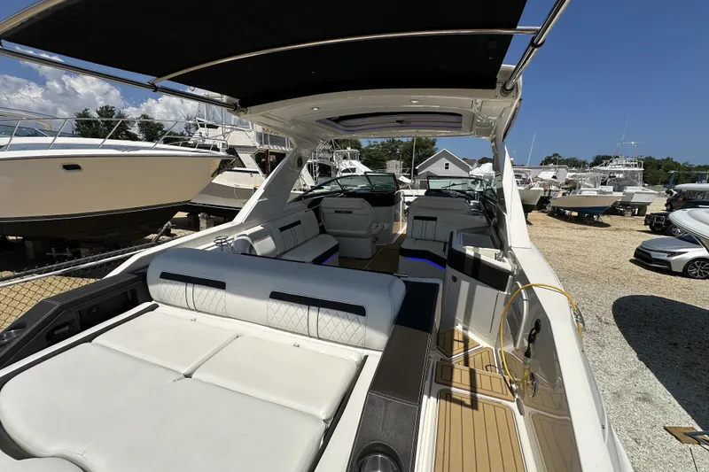 Slide: The Image of 2018 Sea Ray SLX 310 Outboard boat with spacious seating and sleek design in a marina. - 29