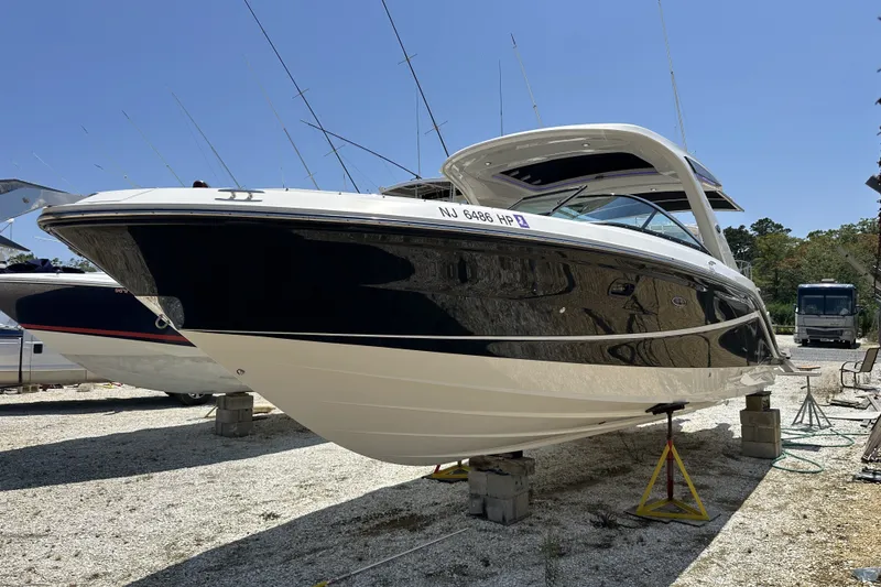 Slide: The Image of 2018 Sea Ray SLX 310 Outboard boat on dry dock, sleek design, sunny day. - 37