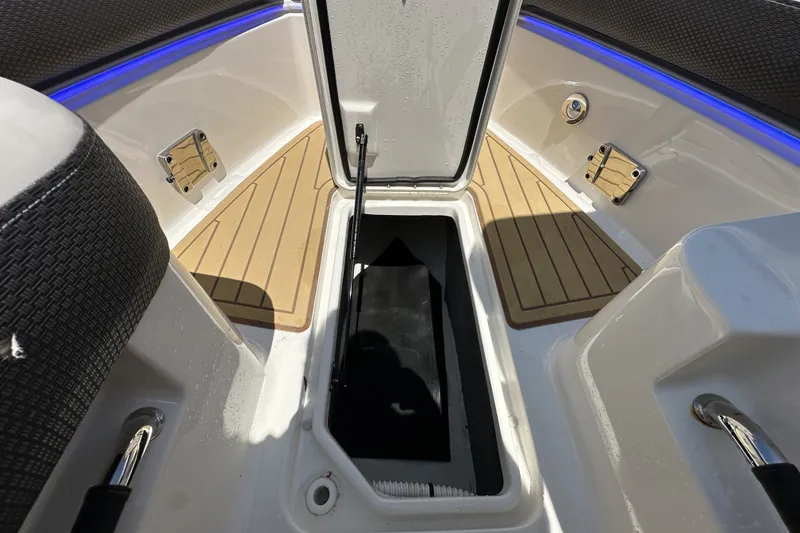 Slide: The Image of 2018 Sea Ray SLX 310 Outboard boat storage compartment with open hatch and teak flooring. - 16