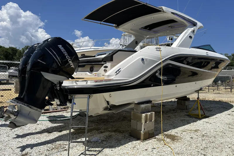 Slide: The Image of 2018 Sea Ray SLX 310 Outboard boat on blocks, featuring dual Mercury engines. - 3
