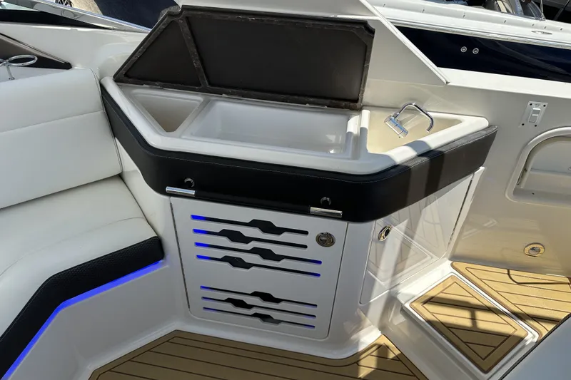 Slide: The Image of 2018 Sea Ray SLX 310 Outboard boat interior with sink and seating area. - 10