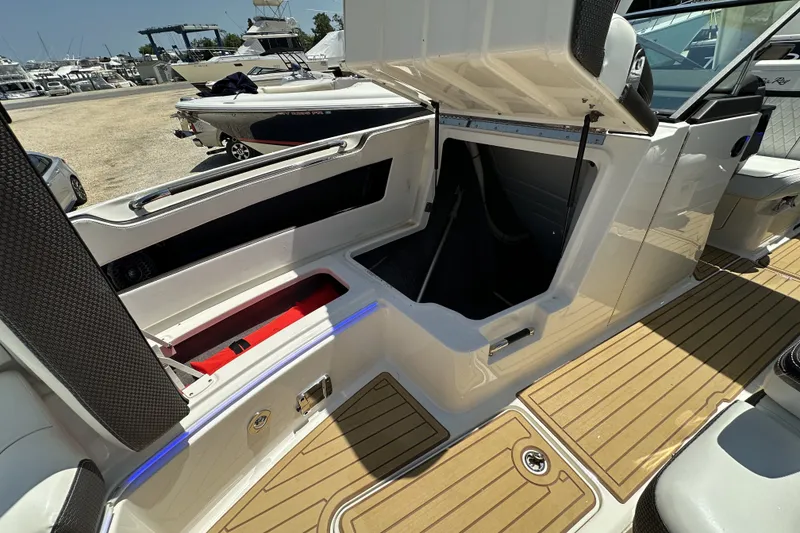 Slide: The Image of 2018 Sea Ray SLX 310 Outboard boat interior with open storage compartment. - 14