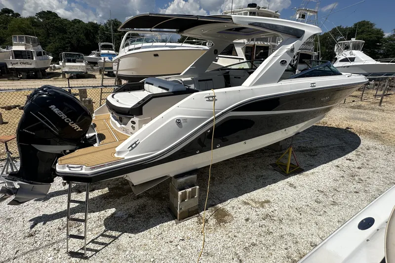 Slide: The Image of 2018 Sea Ray SLX 310 Outboard boat with Mercury engine, docked on gravel. - 1