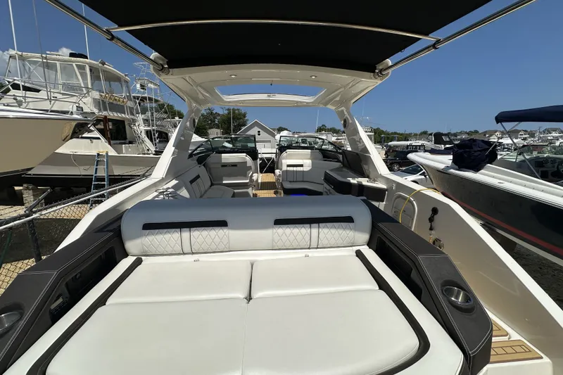 Slide: The Image of 2018 Sea Ray SLX 310 Outboard boat with spacious seating and sleek design at a marina. - 27