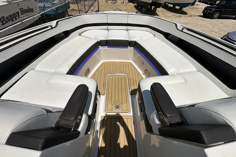 Slide: The Image of 2018 Sea Ray SLX 310 Outboard boat interior with white seating and teak flooring. - 12