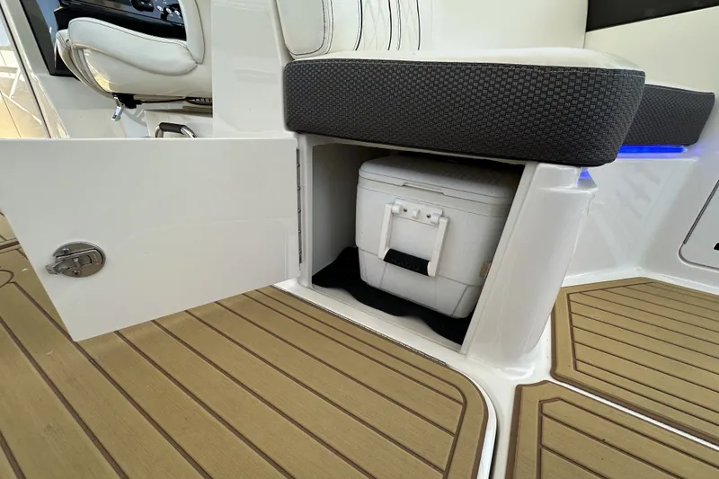 Slide: The Image of Storage compartment with cooler on 2018 Sea Ray SLX 310 Outboard boat, featuring teak flooring. - 31