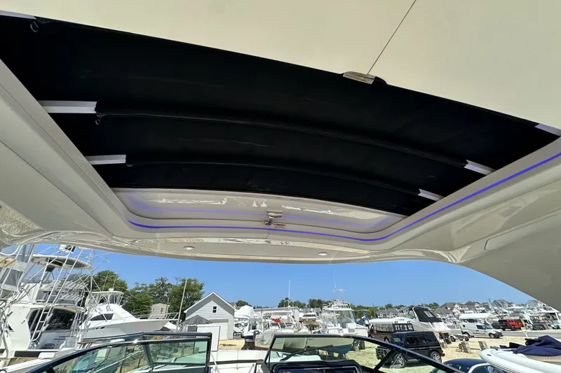 Slide: The Image of 2018 Sea Ray SLX 310 Outboard boat with open sunroof, docked at marina. - 34