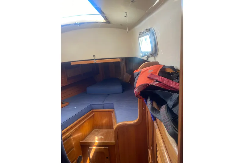 Slide: The Image of Interior cabin of a 1982 Bristol 40 sailboat with wooden furnishings and cushions. - 9