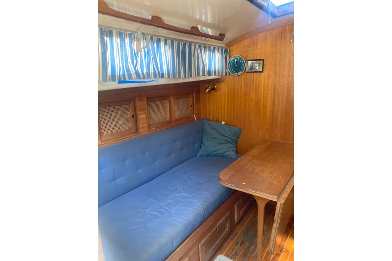 Slide: The Image of Cozy interior of 1982 Bristol 40 sailboat with blue cushions and wooden furnishings. - 6