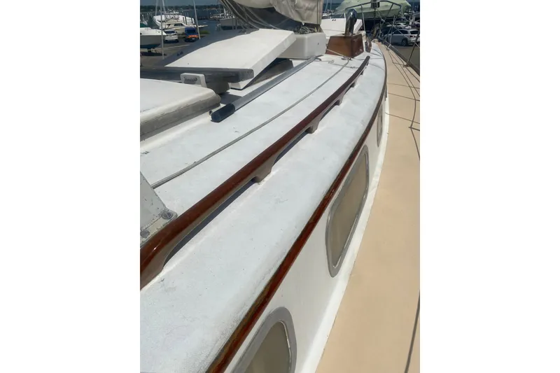 Slide: The Image of 1982 Bristol 40 sailboat deck with wooden trim and docked marina view. - 18