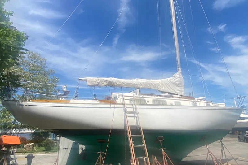 Slide: The Image of 1982 Bristol 40 sailboat on stands, with blue sky background. - 22