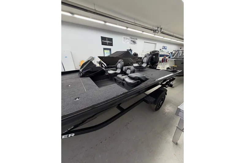 Slide: The Image of 2026 Crestliner XFC 179 fishing boat in showroom, featuring spacious deck and seating. - 4