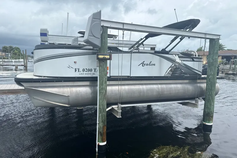 The Image of 2021 Avalon LSV 2285 QL pontoon boat on lift, docked by waterfront. - 0