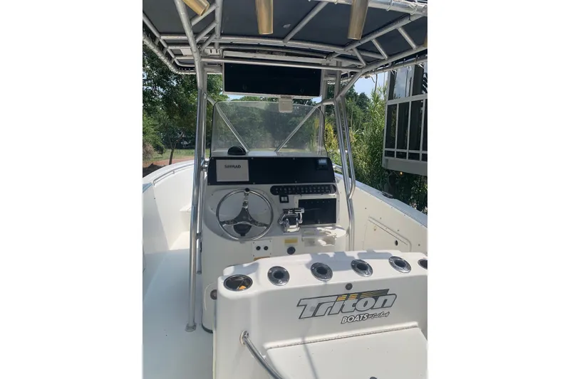 Slide: The Image of 2005 Triton 2895 CC boat cockpit with steering wheel and control panel. - 11