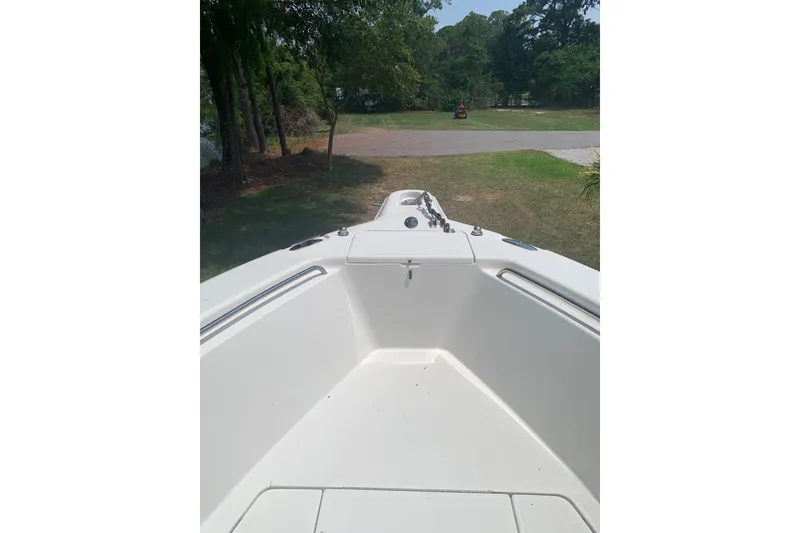 Slide: The Image of 2005 Triton 2895 CC boat interior, showing bow area with trees in the background. - 16