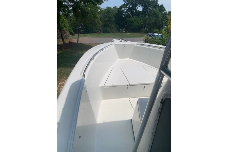 Slide: The Image of 2005 Triton 2895 CC boat interior with white seating and open deck. - 18