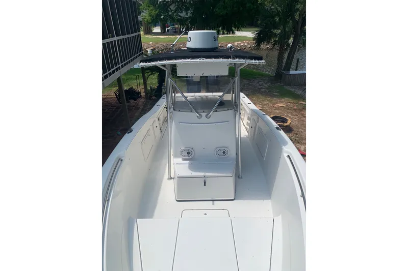 Slide: The Image of 2005 Triton 2895 CC boat with center console and canopy, docked near a waterfront. - 19