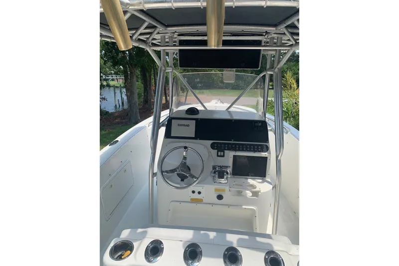 Slide: The Image of 2005 Triton 2895 CC boat cockpit with steering wheel and navigation equipment. - 14