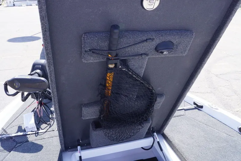 Slide: The Image of 2027 Skeeter FXE20 Limited boat storage compartment with fishing net and equipment. - 29