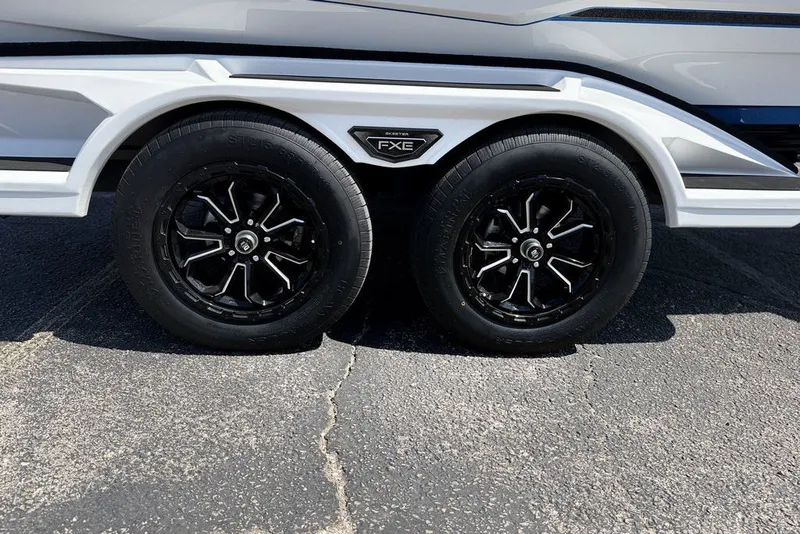 Slide: The Image of 2027 Skeeter FXE20 Limited trailer wheels on asphalt pavement. - 3