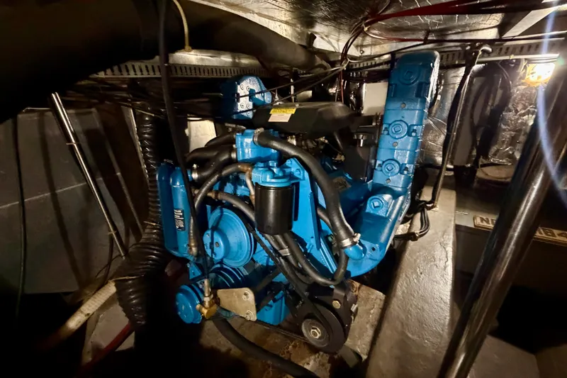 Slide: The Image of Engine room of a 1994 Carver 440 Aft Cabin Motor Yacht, featuring a blue engine. - 30