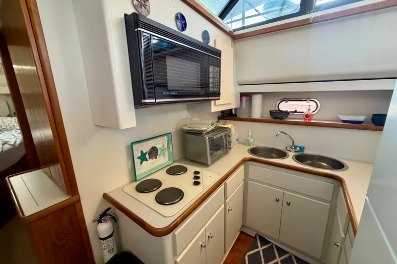 Slide: The Image of Compact kitchen in a 1994 Carver 440 Aft Cabin Motor Yacht with stove, microwave, and dual sinks. - 19