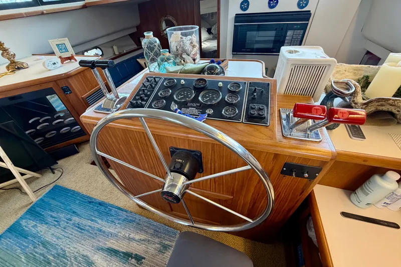 Slide: The Image of 1994 Carver 440 Aft Cabin Motor Yacht helm with steering wheel and control panel. - 15