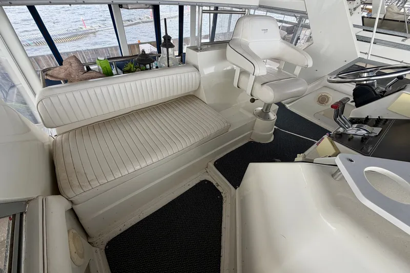 Slide: The Image of Interior of 1994 Carver 440 Aft Cabin Motor Yacht with white seating and helm. - 8